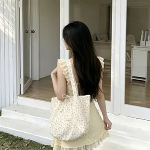 Detail of floral chiffon tote bag showing delicate flower prints and a woven brand label