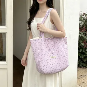Close-up of light purple floral tote bag with bow detail and brand label