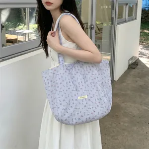 Detail of floral chiffon tote bag with drawstring closure and brand label patch