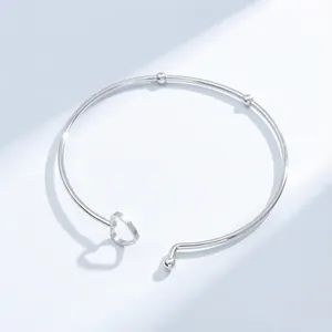 Minimalist stainless steel open heart bangle featuring a polished silver-tone finish