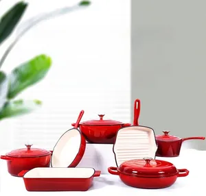 Detailed set of red enameled cast iron cookware including round Dutch oven and frying pans