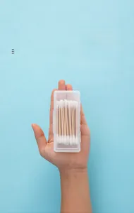 Handheld view of a mini transparent plastic organizer box for cotton swabs and toothpicks
