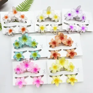 Detail view of tropical plumeria hair claw clips and side pins set in vibrant marble colors