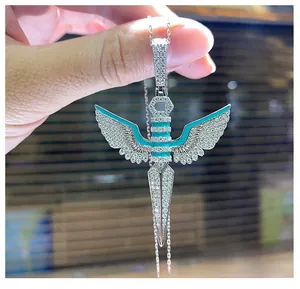 Macro shot of S925 gold-plated sword and angel wings pendant with turquoise enamel and zircon