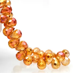 Macro shot of faceted amber glass teardrop beads showing precision cut and high refraction