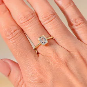 Close-up of S925 silver gold-plated ring with emerald cut zircon in bezel setting