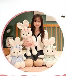 Soft plush rabbit dolls in pink, blue and green floral dresses shown in cozy bedroom