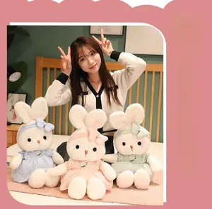 Three cute plush rabbits wearing colorful floral dresses and matching bow headbands