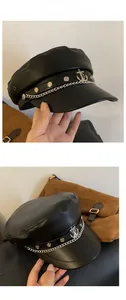 Detail of black PU leather baker boy hat with silver chain and anchor charm decoration