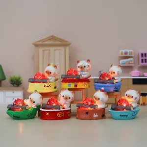 Close-up of cat figurines with glowing fire spirits on decorative bases in mini kitchen scene