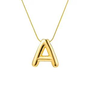 Gold bubble letter A pendant necklace with minimalist snake chain on white background