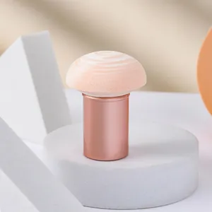 Pink mushroom sponge makeup puff with rose gold handle on a white display pedestal