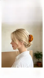 Detailed view of a large amber tortoiseshell acetate hair claw clip for elegant styling