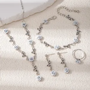 Detail view of a rose jewelry set with silver base and light blue floral accents