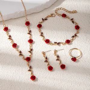 Flat lay detail of red rose jewelry set including necklace, bracelet, ring and earrings