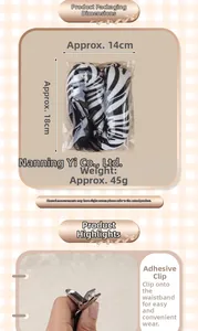 Detail showing plush zebra tail accessory with a metal clip for easy clothing attachment