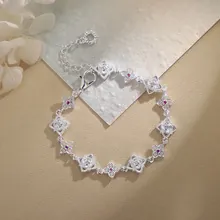 Close-up of silver hollow floral bracelet with sparkling white and red zircons
