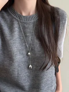 Silver adjustable long necklace with double water drop pendants on a knit sweater