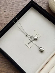Detailed view of polished silver water drop pendants with adjustable sliding bead chain