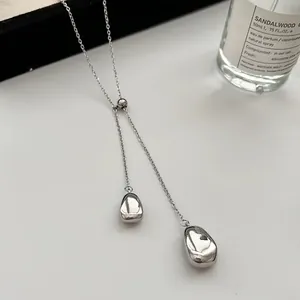 Detail of adjustable silver teardrop necklace with polished metallic Y-chain pendants