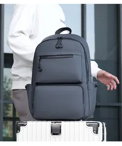 Close-up of waterproof dark gray business backpack placed on a rolling suitcase trolley