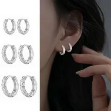 Set of three silver twisted hoop earrings with elegant wave design and textured finish