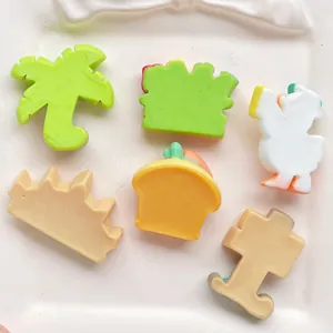 Macro view of colorful resin cartoon charms including duck, palm tree, and cupcake crafts