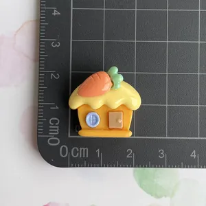 Close-up of resin carrot house DIY accessory with size measurement on a grey mat