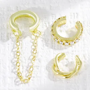 Vista detallada del set de ear cuffs dorados con cadenas, cristales y diseños geométricos
