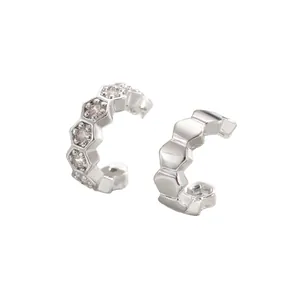 Detalle de pendientes de clip hexagonales con acabado pulido y piedras de circón brillante