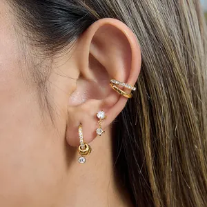 Gros plan de boucles d'oreilles en acier inoxydable doré avec zircon sur l'oreille