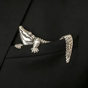 Silver crocodile brooch with vintage finish crawling from black suit pocket edge