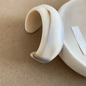 Irregular wide open cuff bracelet in cream white marble resin with a minimalist design