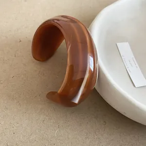 Modern amber-colored resin bangle with wide irregular design and natural marble texture