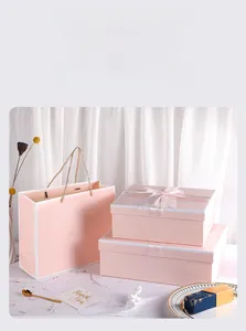Detailed view of pink gift box set with satin ribbons and matching carrier bag handles