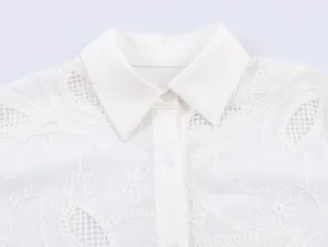Close-up of white shirt collar with intricate floral embroidery and button detail