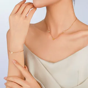 Minimalist gold heart jewelry set featuring dainty chain necklace and matching bracelet