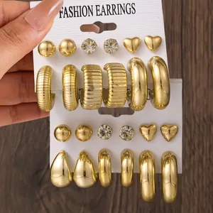 Detailaufnahme eines goldenen Ohrring-Sets mit Steckern und Creolen auf Karten