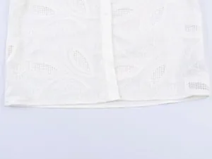 Close-up of white lace embroidery details on casual long sleeve button-up shirt