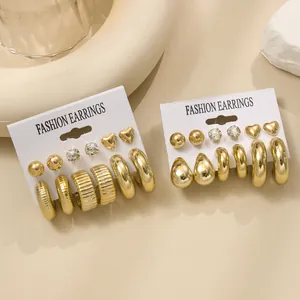 Poliertes goldenes Ohrring-Set mit Creolen und Steckern auf Displaykarten mit Deko