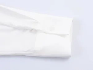 Detail of white cotton shirt cuff with a single button and elegant pleat design