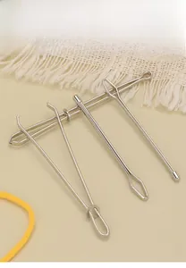 Detailed set of four polished stainless steel threading tools for sewing and DIY craft use