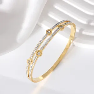 Close-up of golden double-layer steel bracelet with pavé cubic zirconia diamonds