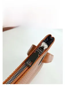 Close-up of crocodile embossed leather texture with premium metal zipper detail