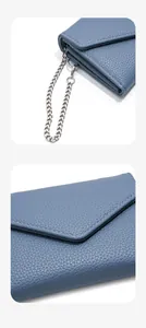 Detailed view of blue litchi grain leather texture and silver chain metal hardware