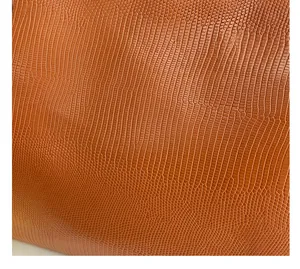 Detailed macro view of orange synthetic leather with fine lizard skin texture and patterns