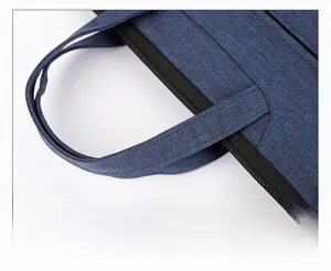 Close-up of widened ergonomic handle on a dark blue oxford fabric business briefcase