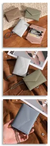 Detailed macro view of litchi texture leather trifold wallet with metallic chain strap
