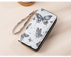 Detail view of white double zipper wallet with black butterfly and star patterns