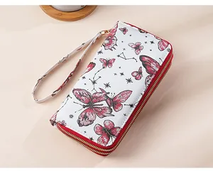 Detailed close-up of a white leather wallet with red butterfly and constellation patterns